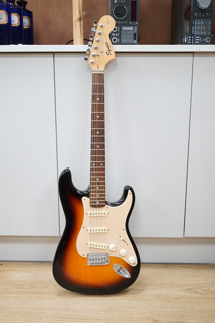 A Fender Squire electric guitar, with a Kinsman soft case, together with a Peavey VYPYR 15W modelling amplifier